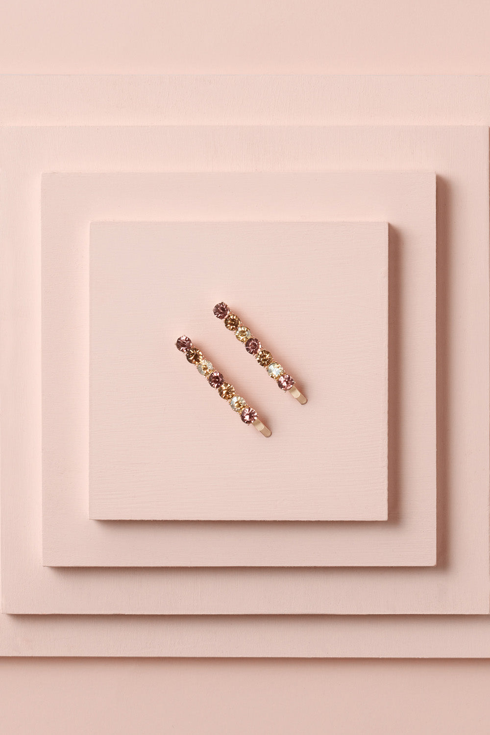 Glow On & Sparkle Gemstone Bobby Pins on a stack of pink boxes 