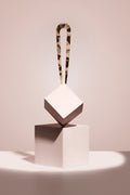 model with tortoise chignon u shaped pin presented on a cube